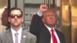 Trump fist pumps support for the crowd supporting him as he heads to the NY courthouse