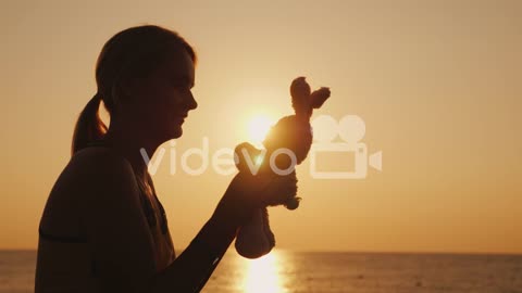 Silhouette A Woman Is Playing With A Toy Bunny At Dawn Remember Childhood 4k Video