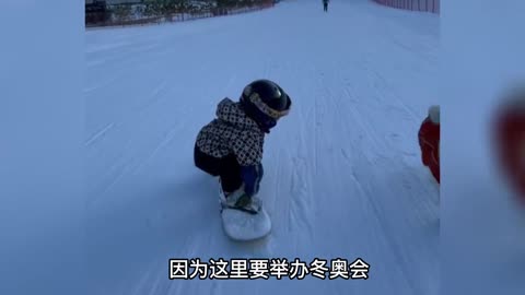 Little cute baby less than 1 year old, she can't walk well, but she can snowboard
