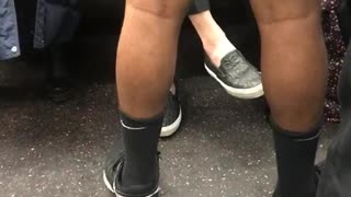 Man wears jacket and shorts on subway