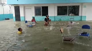 Niños nadando en instalaciones inundadas en Gambote