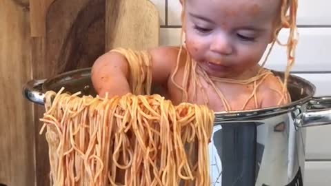 A cute baby helps mom make pasta