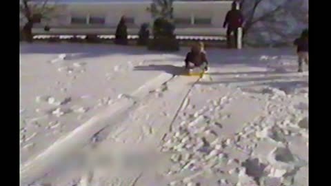 Two Girls On Sled Crash Into The Side Of A House