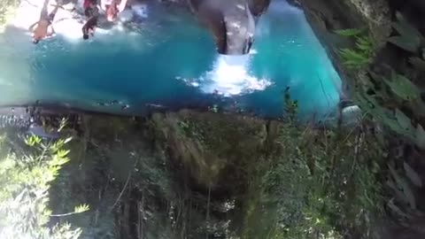 A couple riding a natural water slide.