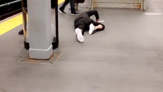 Man black outfit on floor of station near stairs