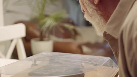 An Elderly Man Preparing to Use His Turntable