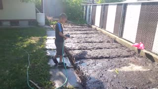 dad teaches son how to water the garden.