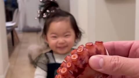 Will the cute baby eat the octopus leg