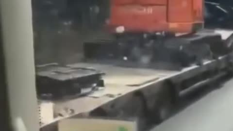 Lorry knocks digger off of trailer by hitting bridge