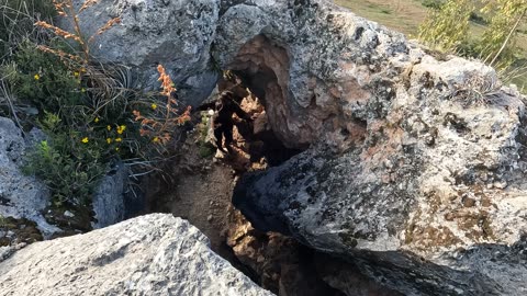 Climbing through the natural stone arch in Cusco