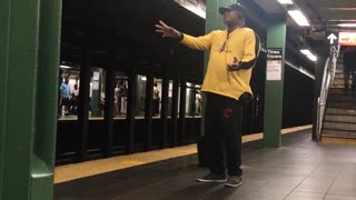 Man in yellow jacket singing in subway