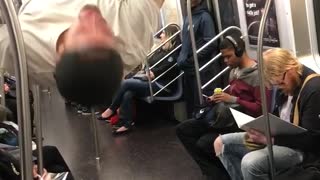 Man in white shirt performing on subway train