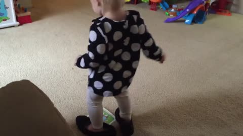 Pequeña niña camina con los zapatos de su mamá