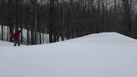 Skier skis off ramp and lands on back and butt, skis fly off feet
