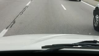 Police Car Rides in Two Lanes on Highway