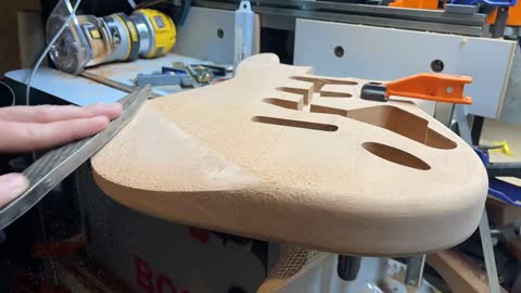 Shaping arm contour on a Stratocaster body.