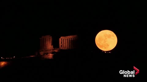 “Strawberry” supermoon rises behind ancient coastal Greek temple