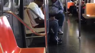 Man switching blue and red hats on train