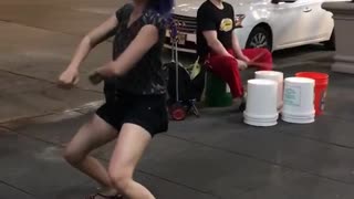 Woman shorts dancing street performer drums