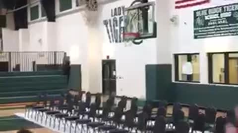 Kid holds onto basketball net lands on back