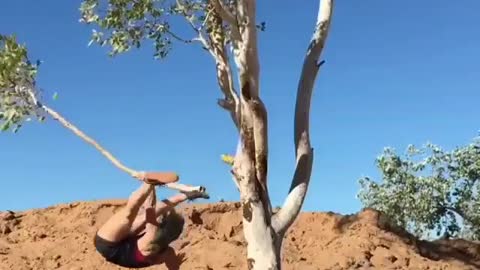 Fitness Girl fall with tree stem while doing workout on tree