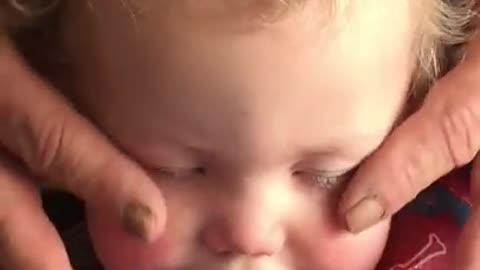 Grandpa gives baby relaxing face massage