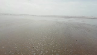 Atlantic sea wildly sweeping over the sand in windy storm