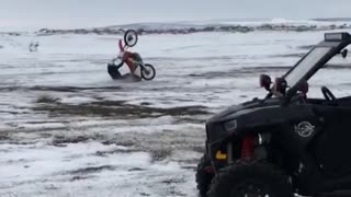 Guy red motorcycle wheelie snow fall