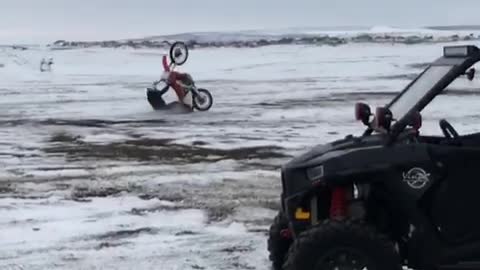 Guy red motorcycle wheelie snow fall