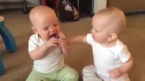 Twin baby girls fight over pacifier