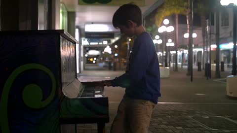 Young Boy Playing Piano in the Street