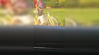 Woman rides bike with baby in bag