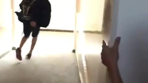 Two school kids run through hall one hits self on wall