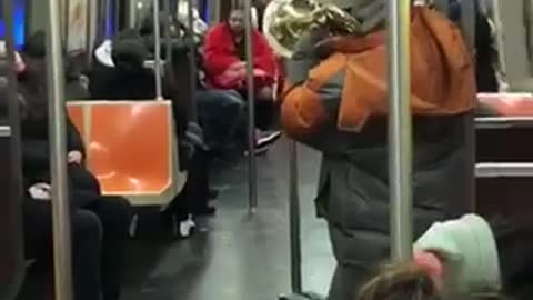 Man playing trumpet with throw up on subway floor