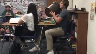 Guy records his friend throwing trashcan across classroom