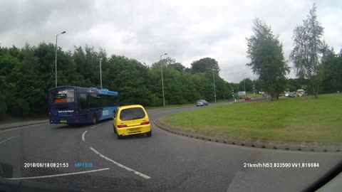 Reckless driver barely passes bus on roundabout