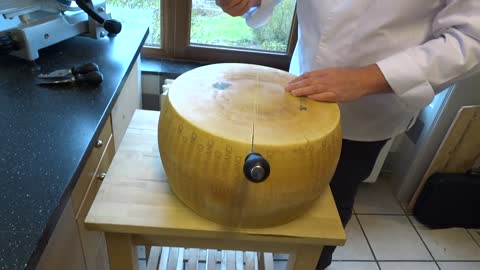 opening a wheel of parmesan cheese (parmigiano reggiano)