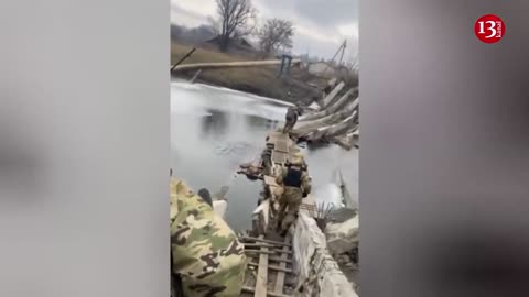 Under fire, Ukrainian fighters are crossing the river through a destroyed bridge in Bakhmut