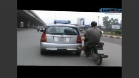 Taxi getting pushed by motobike