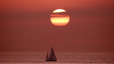 View of the horizon in the sea while a sailboat sails