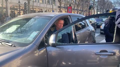 Police smash the window of a convoy for freedom vehicle on the Champs-Élysées in Paris