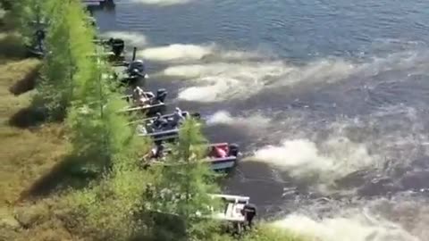 Boat owners moving a large floating island out of the way on Wisconsin's Lake