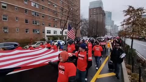 100s of NYC workers carry an American and Canadian flag