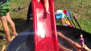 Brother unexpectedly pushes little sister down water slide