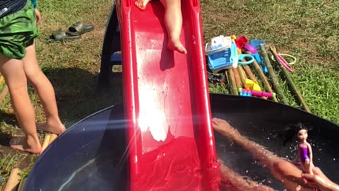 Brother unexpectedly pushes little sister down water slide