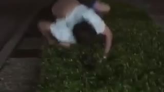 Guy in white shirt on grass fail at back flip