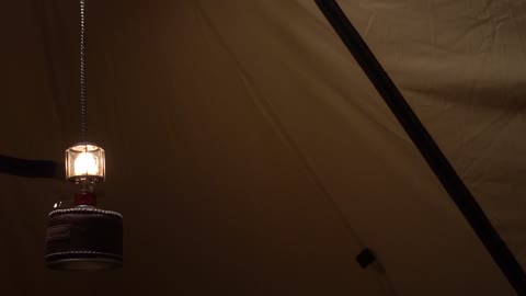 A lamp shining brightly in a dark tent 2