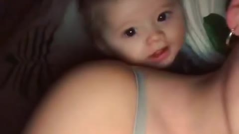 Cute baby laughing with mom on bed !