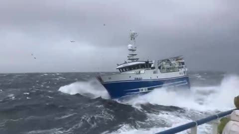 A small ship is hit by a sea storm.
