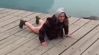 Girl back flips on lake dock face plant